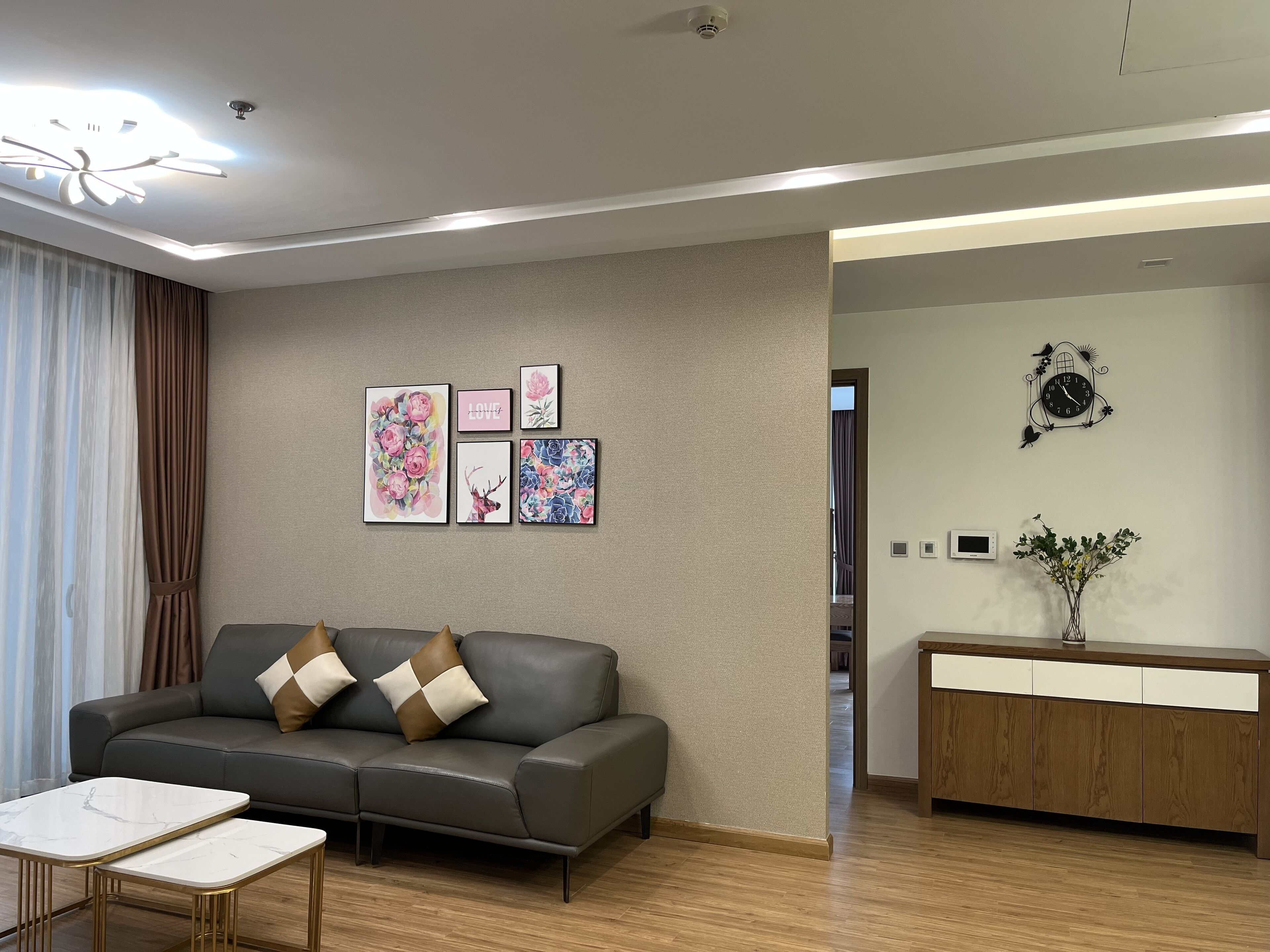 A modern living room with a grey sofa, a coffee table, and a wooden cabinet.