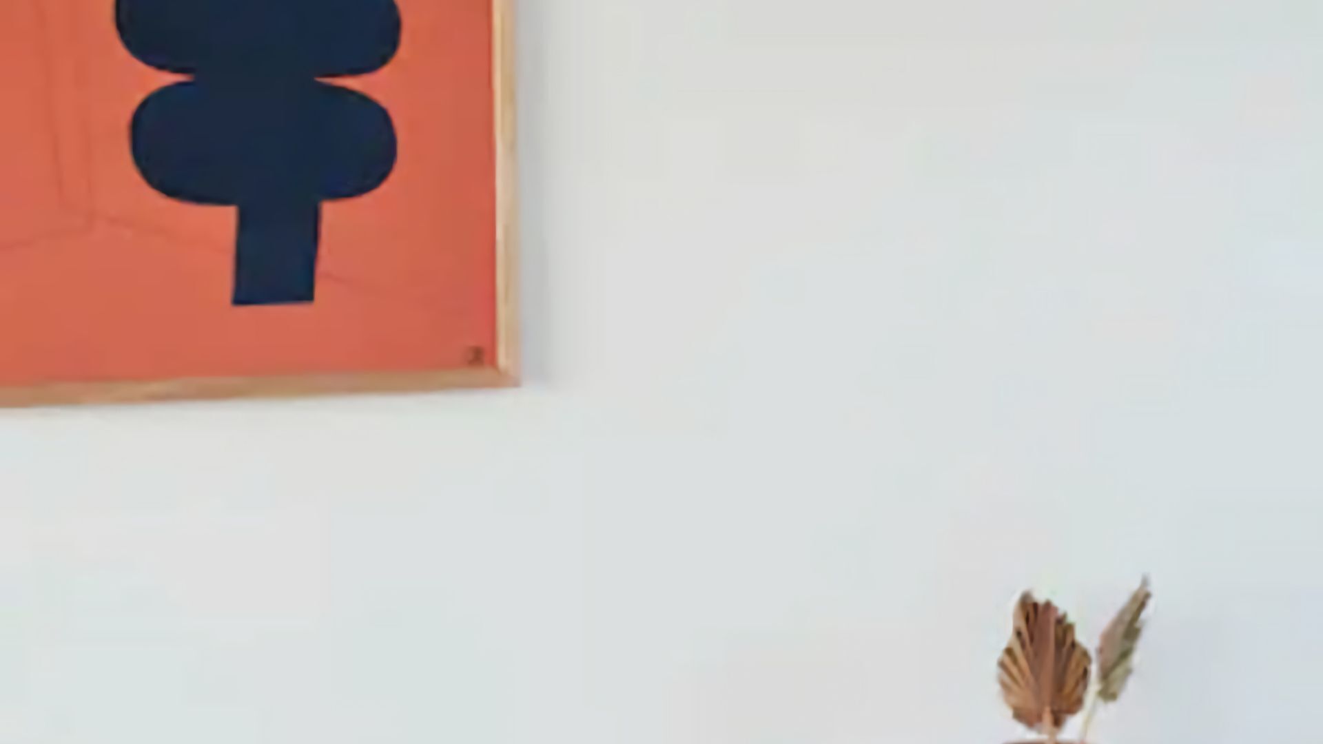 A framed artwork with a dark blue abstract design on an orange background.