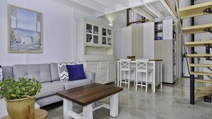 Relax in this inviting living space with a sofa, coffee table, and kitchen area.