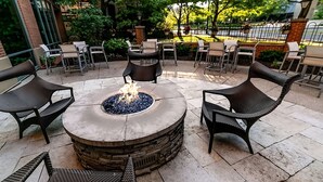 An outdoor seating area with a circular fire pit surrounded by wicker chairs. - Gateway to Columbus' Wonders! Pet-friendly Unit Close to Victorian Village (Columbus)