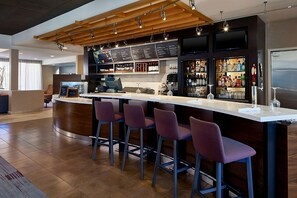 A modern bar area with a wooden ceiling, bar stools, a counter, and a variety of bottles and glasses. - Discover Stylish Comfort! Outdoor Pool & Free Airport Shuttle! (Morrisville)