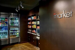 A refrigerated display with various beverages and snacks, and a wall with the text "the market". - Discover Stylish Comfort! Outdoor Pool & Free Airport Shuttle! (Morrisville)