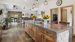 A spacious kitchen with a large island, wooden cabinets, and pendant lighting. - Isabelle Creek Haven - Ultimate Group Getaway (Bay City)