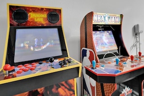 Dos máquinas de videojuegos arcade, una con el rótulo "Dragon's Lair" y la otra "NBA JAM", con controles y botones.