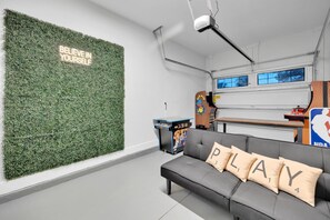 Una habitación moderna con una pared verde, un sofá gris y una frase motivacional.
