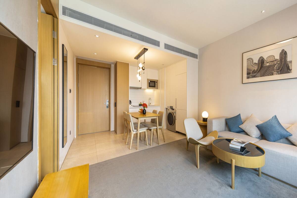 Un salon moderne avec un canapé, une table basse et un coin repas.