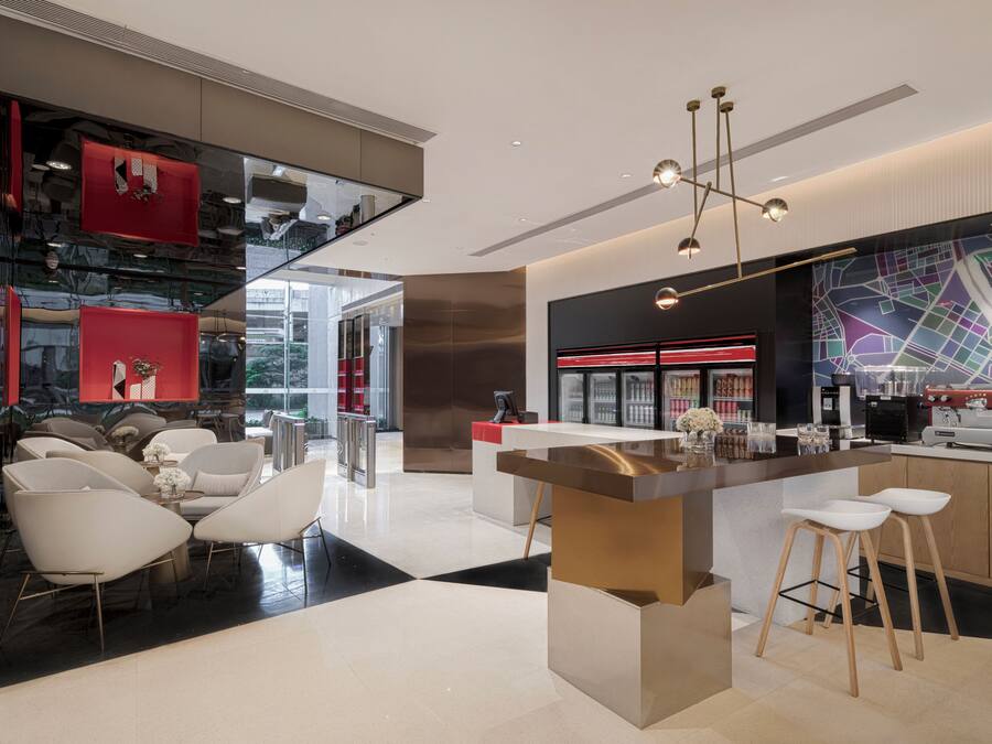 Una cocina moderna con una isla central, taburetes de bar y un ventanal grande.