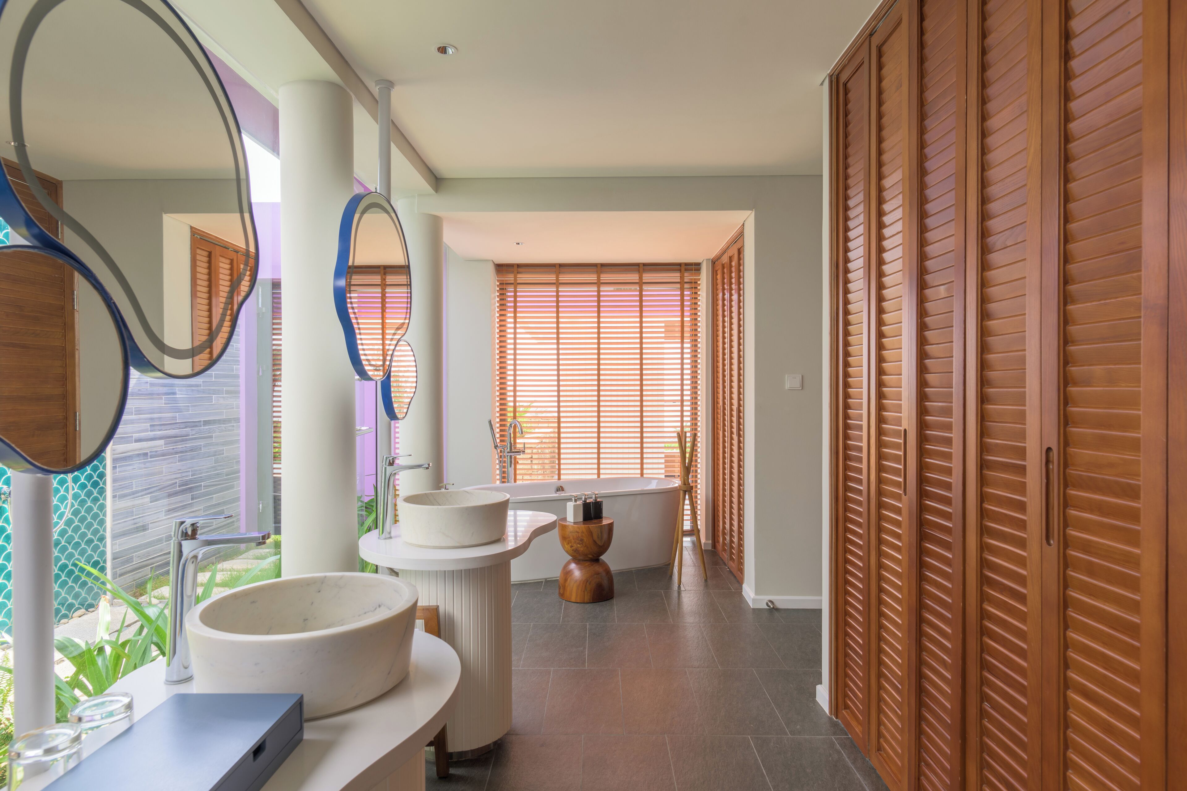 Une salle de bain moderne avec un grand lavabo, une baignoire et des portes coulissantes en bois.