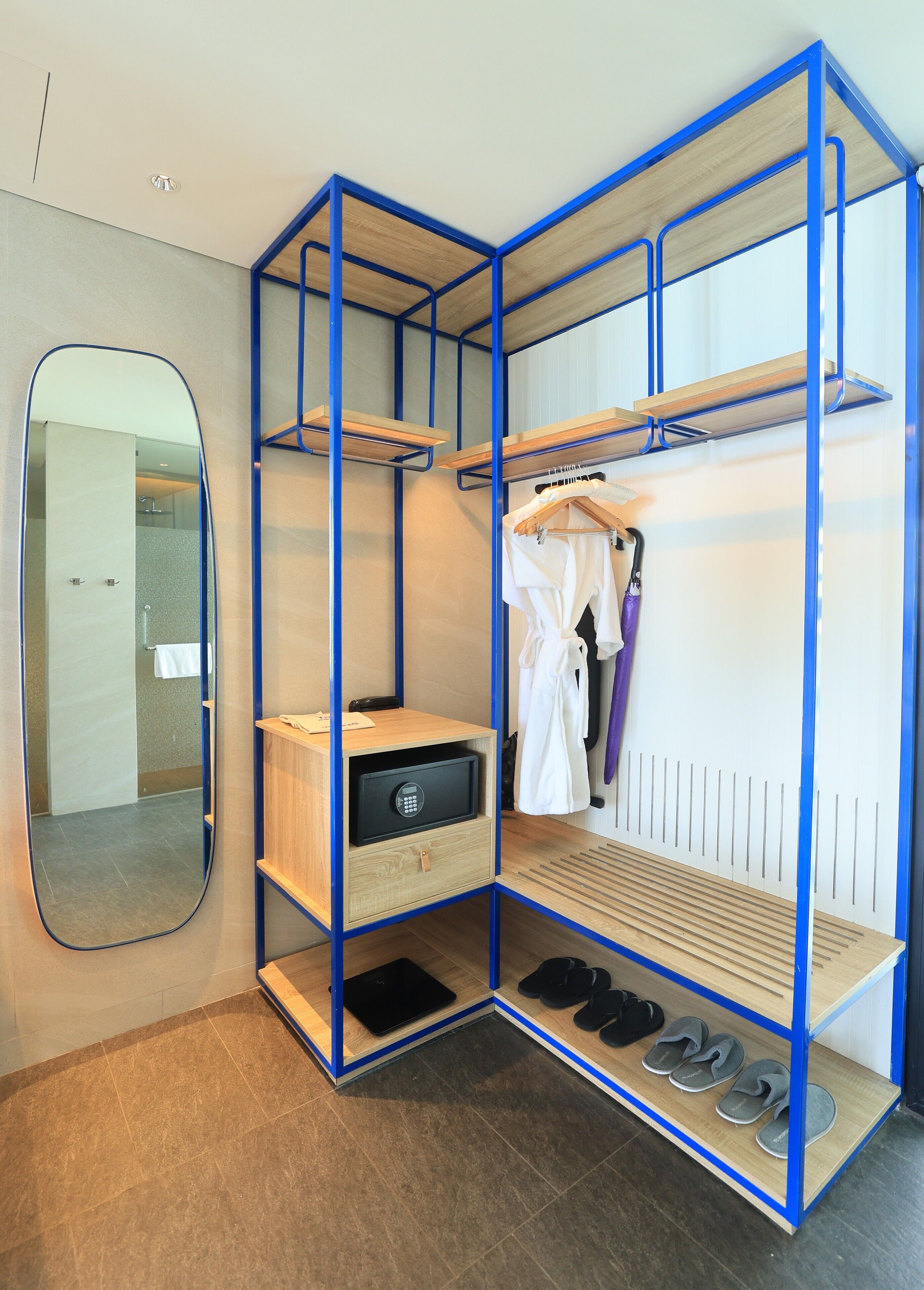 A modern, multi-tiered storage unit with shelves, a shoe rack, and a small safe.