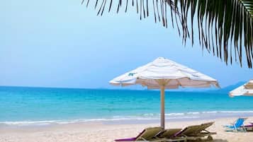 Playa privada, arena blanca, sillas reclinables de playa, sombrillas