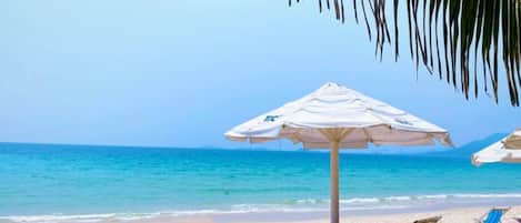 Playa privada, playa de arena blanca, camastros y sombrillas