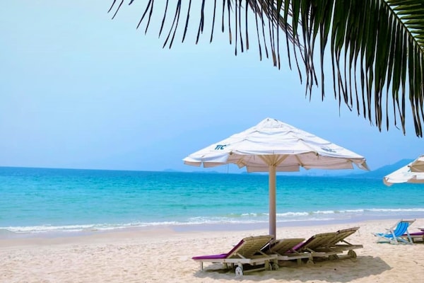 Playa privada, arena blanca, sillas reclinables de playa, sombrillas