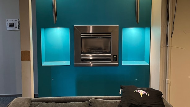 Una cocina moderna con horno empotrado y dos luces fijadas a la pared.