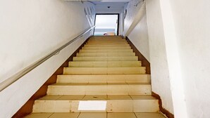 A staircase leading to an upper floor with a view of the sea.