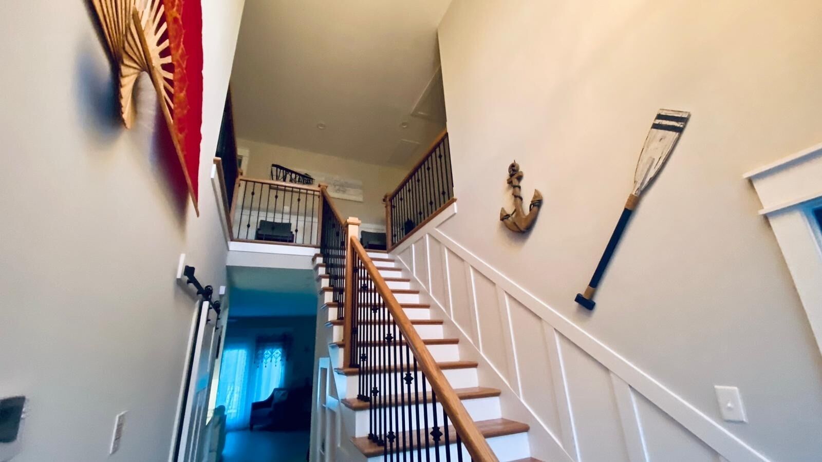 A staircase with wooden railings and a handrail, leading to an upper floor.