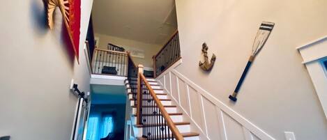 A staircase with wooden railings and a handrail, leading to an upper floor.