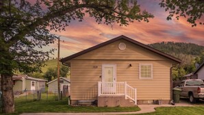 A single-story house with a front porch, a mailbox, and a number '1828' on the door.