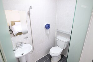 Eenvoudige eenpersoonskamer | Badkamer | Een douche, een haardroger, pantoffels, handdoeken