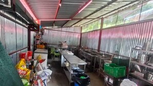 A compact kitchen area with metal walls, a metal roof, and various kitchen appliances and supplies. - Phulwari Resort (Ukhimath)