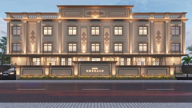 Un hôtel à plusieurs étages, doté d’une façade classique, de grandes fenêtres et d’une entrée imposante.