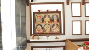 Une salle de bain avec un lavabo en marbre, un miroir et un tableau religieux encadré au-dessus.