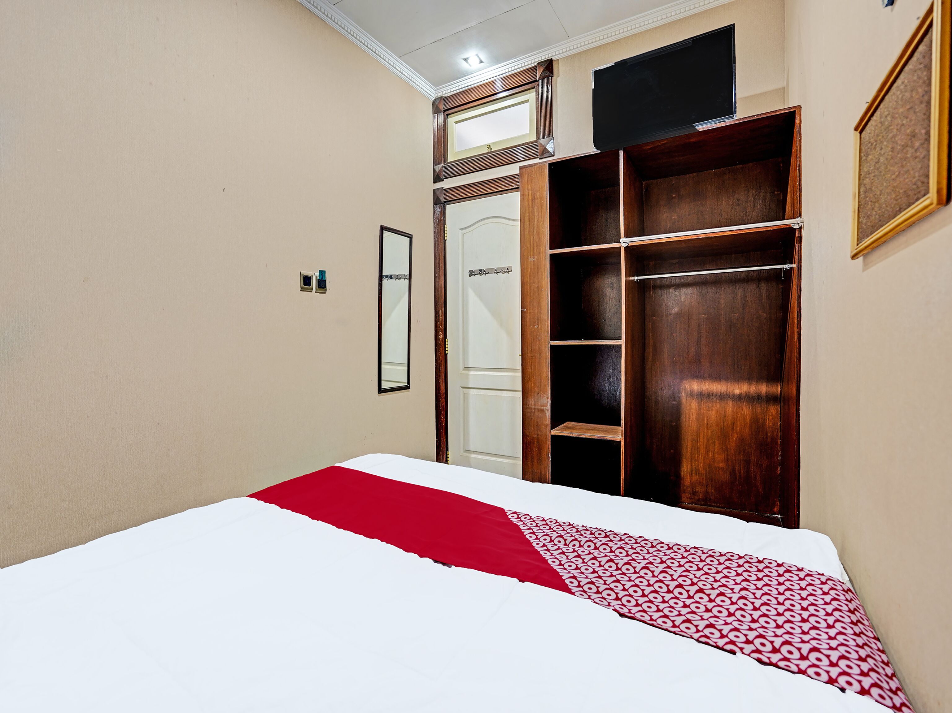 Een slaapkamer met een bed, een kledingkast en een spiegel.