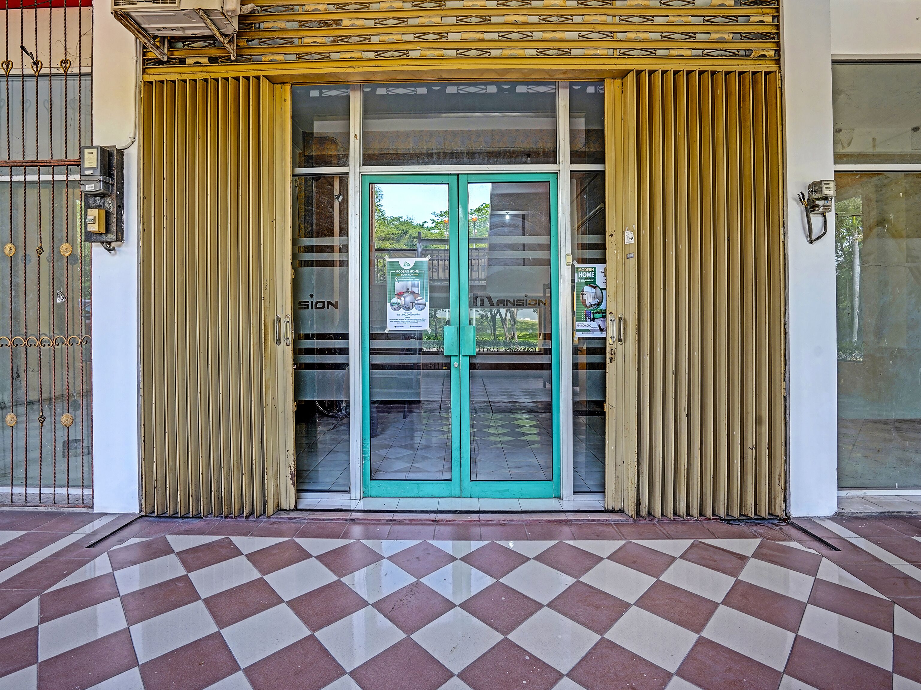 Una entrada de edificio con puerta de vidrio y suelo de baldosas.