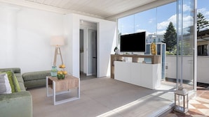 En moderne stue med sofa, sofabord og fjernsyn.