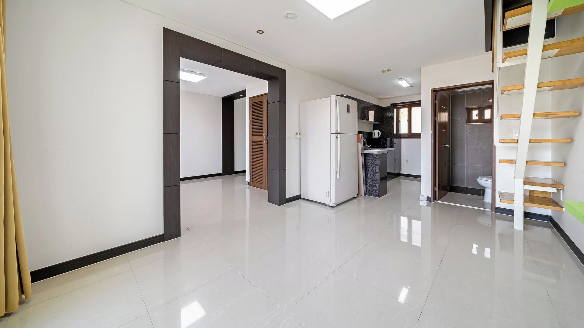 A modern kitchen with a refrigerator, a sink, and a window.