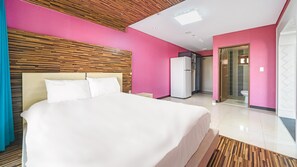 A modern hotel room with a large bed, a wooden headboard, and pink walls. - Geojedo Pilos Ocean View Pension (Geoje)