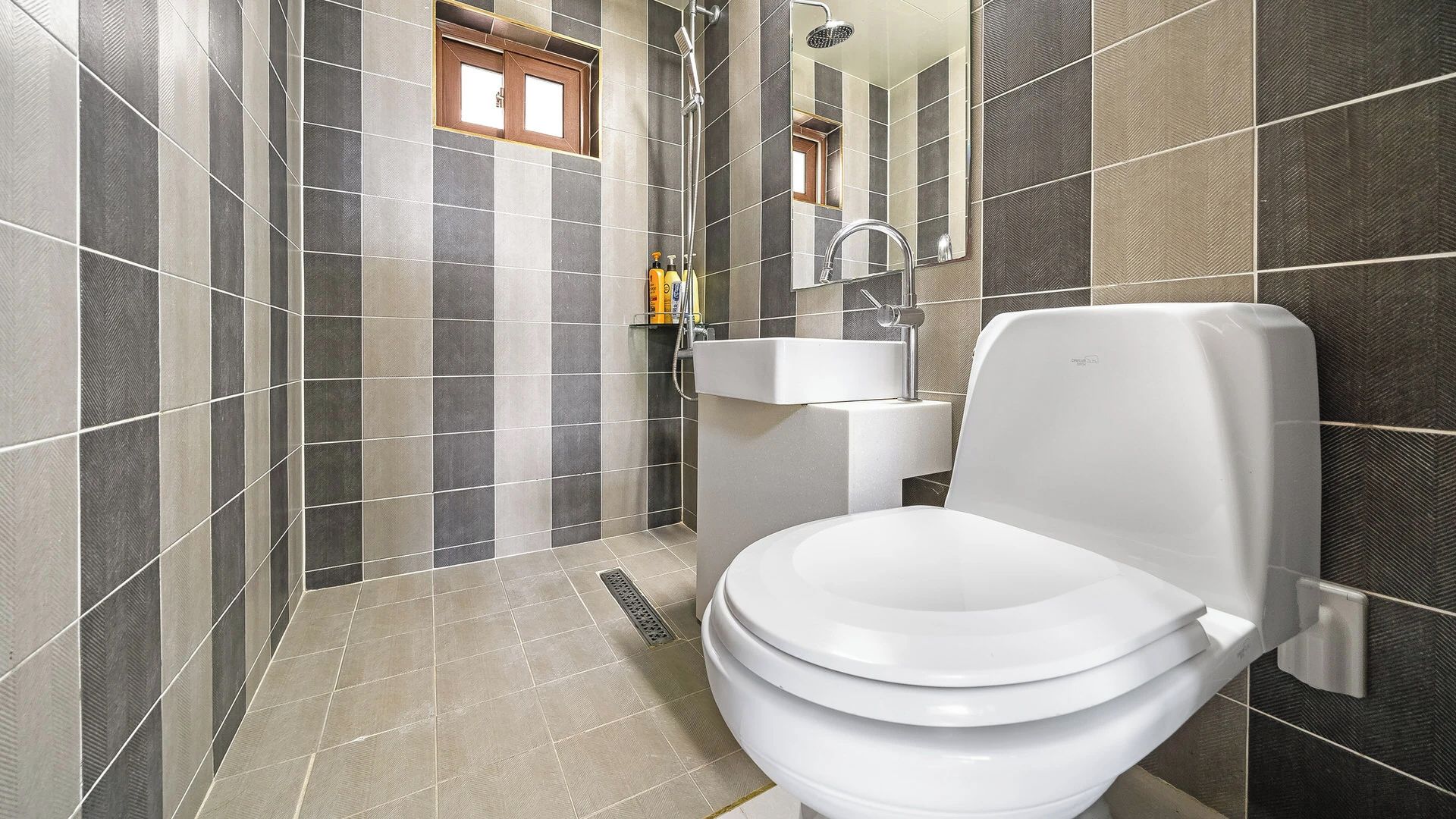 Une salle de bain moderne équipée de toilettes, d’un lavabo et d’une douche.