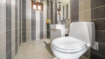Une salle de bain moderne équipée de toilettes, d’un lavabo et d’une douche.