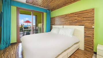 Habitación de hotel con una cama grande, un panel de pared de madera y vistas al exterior.