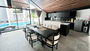 A modern kitchen with a dining area, a pool, and a view of the outdoors. - Exclusive Villa F3 with Jacuzzi - MANA VILLAS (Benoa)