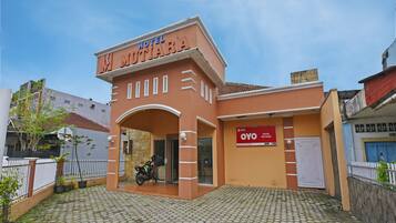 A building with a sign reading "HOTEL MUTIARA" and a smaller sign below it stating "OYO HOTEL MUTIARA".