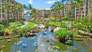 Un hotel con piscina rodeado de plantas tropicales y palmeras.