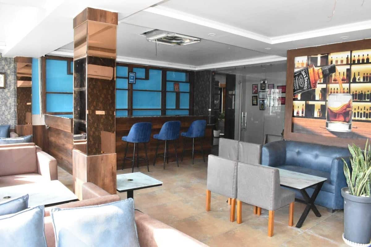 Un área de descanso moderna con asientos, una barra y una exhibición de botellas de licor.