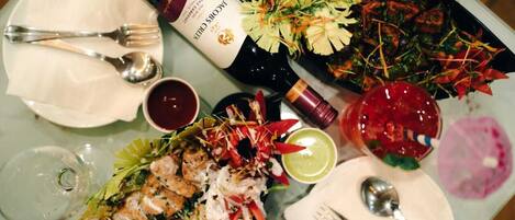 A dining table with various dishes, a bottle of wine, and cutlery.