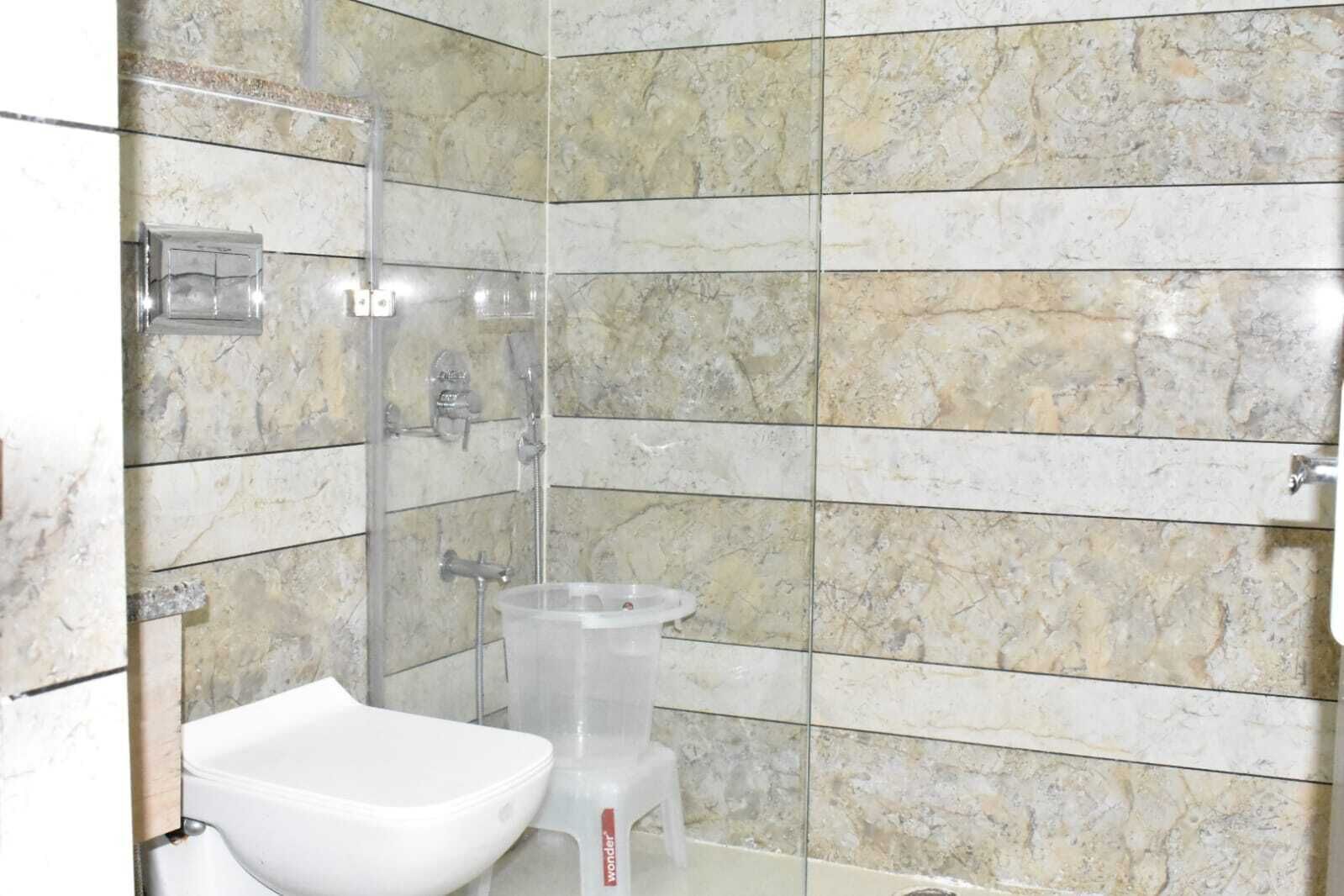A bathroom with a shower, a toilet, and a bidet.