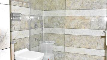 A bathroom with a shower, a toilet, and a bidet.
