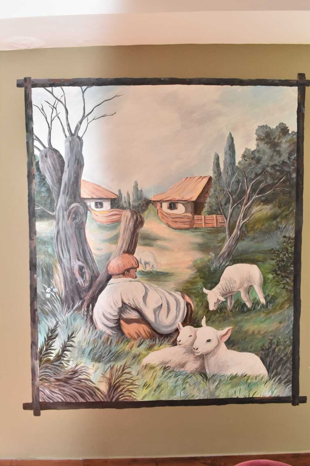 Un mural que muestra una persona, ovejas y casas.