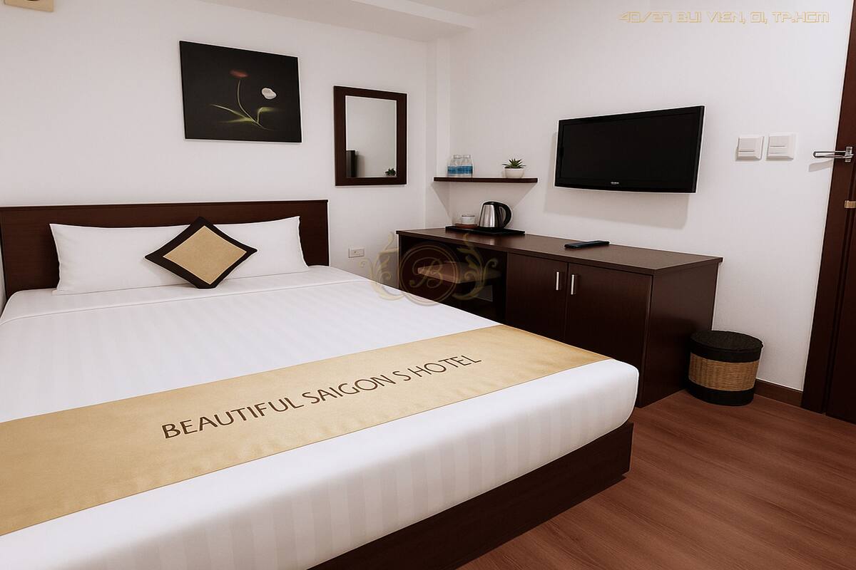 A hotel room with a bed, a TV, a mirror, a shelf with toiletries, and a trash bin.