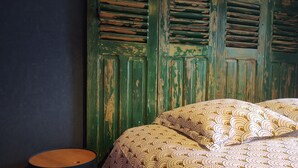 A room with a bed, a small round table, and a green wall with a window. - Gîte Familial Avec Jardin et Garage Clos (OBERENTZEN)