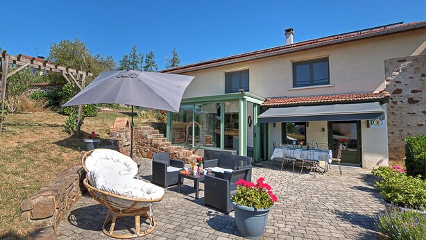 A patio area with outdoor furniture, a stone fireplace, and a covered seating area. - Country house in a village with character (Saint-Galmier)