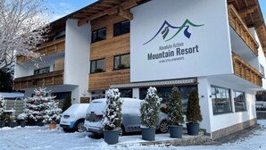 Een gebouw met een bord waarop 'Absolute Active Mountain Resort' staat, met appartementen in Alpenstijl.