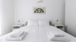 A minimalist bedroom with a large bed, two bedside tables, and a framed picture on the wall. - Italianway Comfort - Bligny 19A D Bologna (Milan)