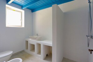 A bathroom with a white sink, a toilet, and a shower. - Bibi - Danilia Cottages (Paxos)