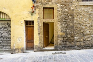 Un edificio in pietra con una porta di legno e una finestra.