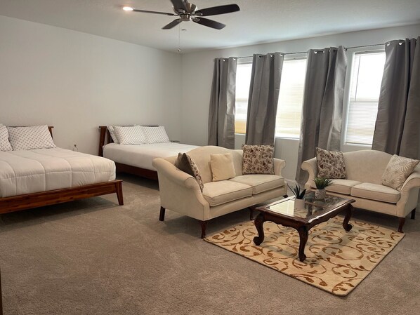 A bedroom with a bed, two sofas, a coffee table, and a ceiling fan. - Charming Sequoia Vista - Beautiful brand new house , just 25 min to Sequoia NP (Visalia)