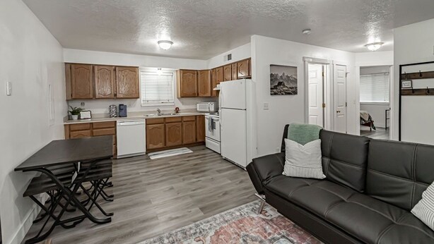 Un espacio habitable compacto con kitchenette, comedor y sofá.
